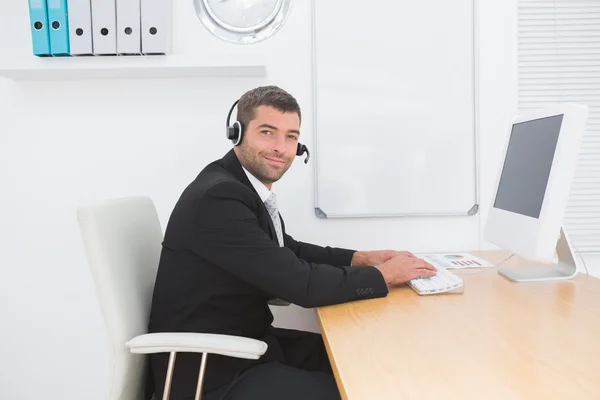 Hombre de negocios con auriculares sonriendo —  Fotos de Stock