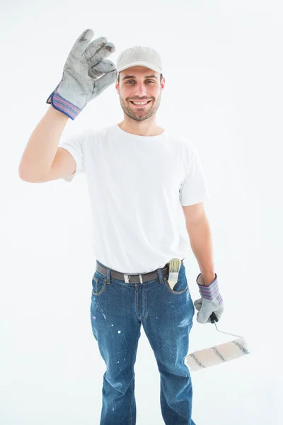 Man wearing gloves while holding paint roller — Stock Photo, Image