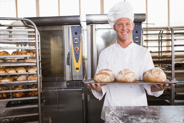 Baker showing tray of fresh bread — Stock Photo, Image