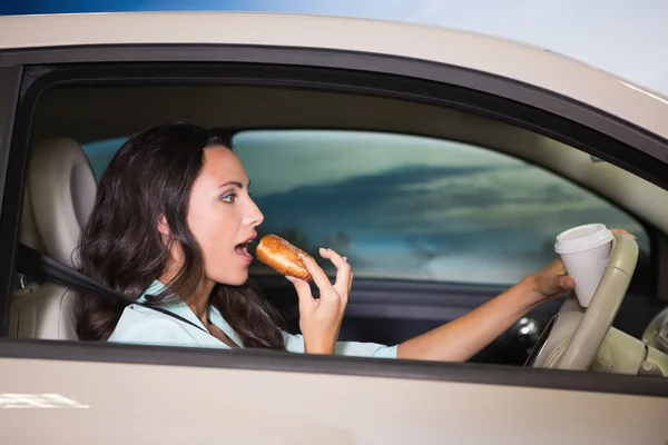 Mulher bebendo café e comer donuts — Fotografia de Stock