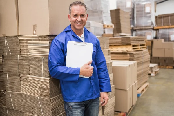 Arbeiter lehnt auf einem Haufen Pappe — Stockfoto