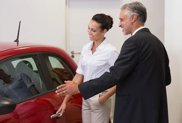 Empresário mostrando um carro para uma mulher — Fotografia de Stock