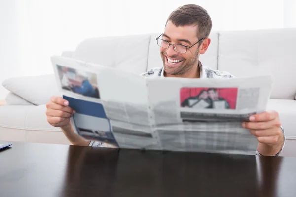 Hombre sonriente leyendo un periódico — Foto de Stock