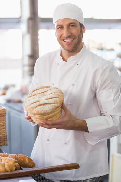 Happy baker with loaf of bread — Stock Photo, Image