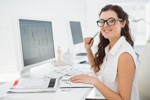 Smiling businesswoman sitting at desk — Stock Photo, Image