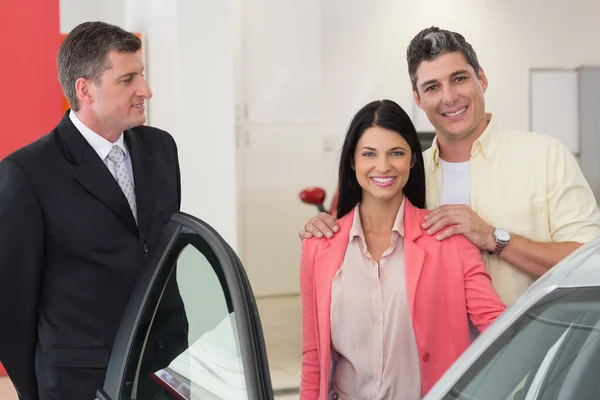 Lächelndes Paar kauft ein neues Auto — Stockfoto