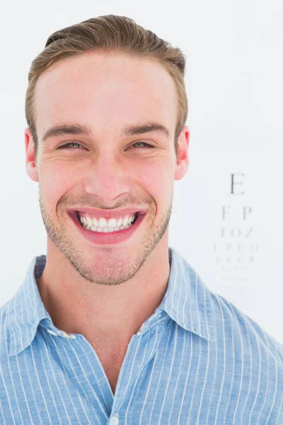 Feliz guapo en camisa delante de la prueba del ojo — Foto de Stock