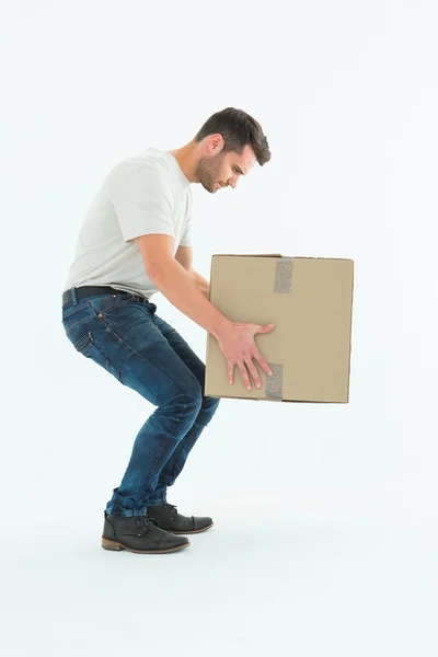 Courier man picking up cardboard box — Stock Photo, Image