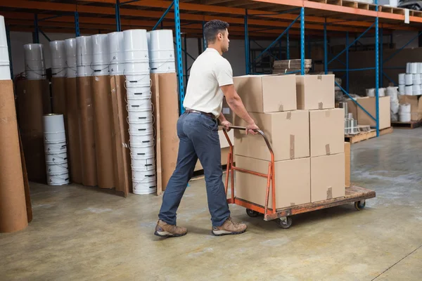 Arbeiter schiebt Einkaufswagen mit Kisten — Stockfoto