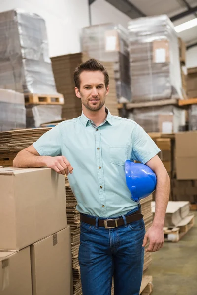 Warehouse worker leaning against boxes — Stock Photo, Image