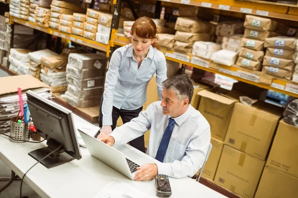 Warehouse managers working together on laptop — Stock Photo, Image