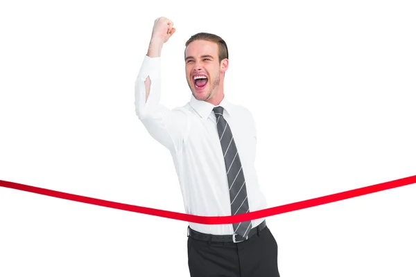 Businessman crossing the finish line while clenching fist — Stock Photo, Image