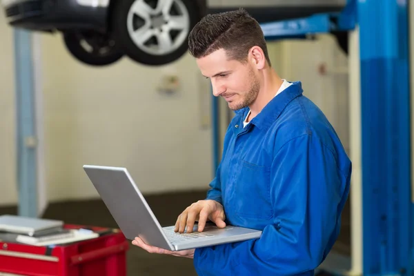 Mechanic met behulp van een laptop te werken — Stockfoto