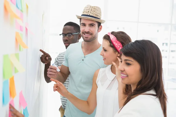 Compañeros de trabajo hablando de ideas sobre notas adhesivas — Foto de Stock