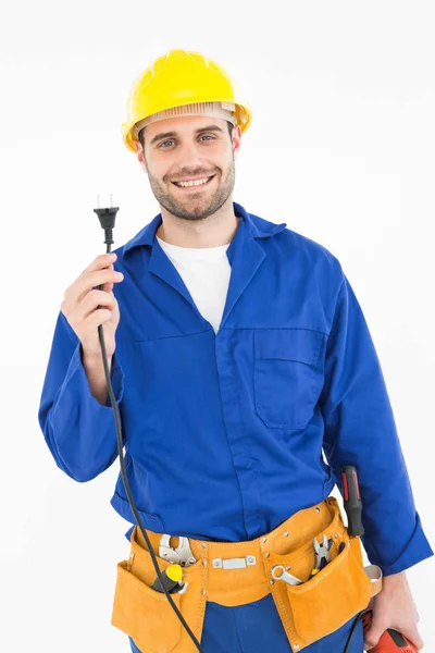 Reparador sonriente sosteniendo enchufe eléctrico — Foto de Stock