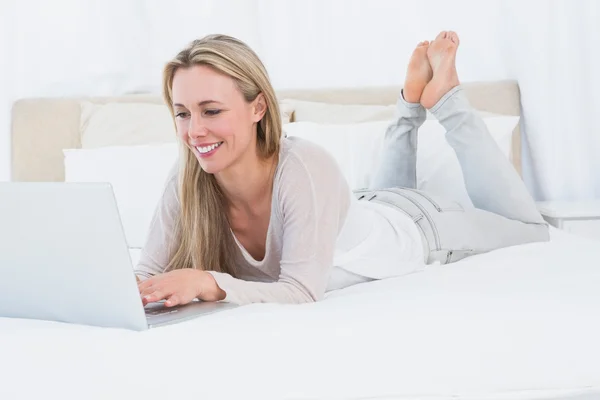 Loira digitação no laptop na cama — Fotografia de Stock