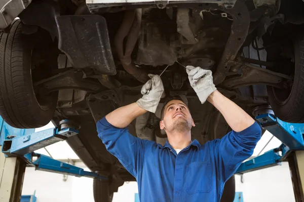 Mechaniker untersucht unter dem Auto — Stockfoto