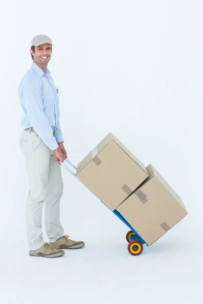 Entrega homem empurrando carrinho de caixas — Fotografia de Stock