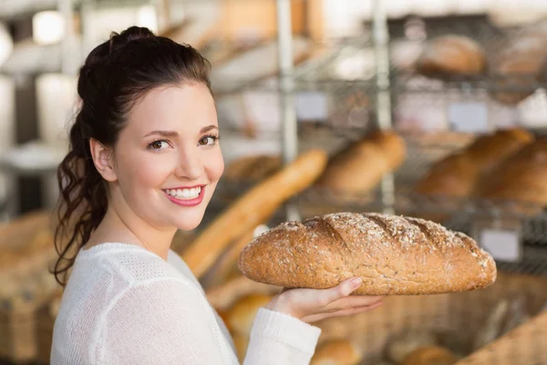 Pretty brunette holding loaf of bread — Stock Photo, Image