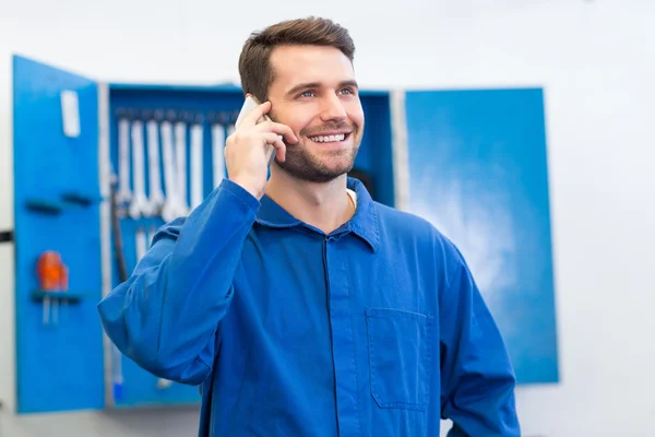 Usmívající se mechanik na telefonu — Stock fotografie