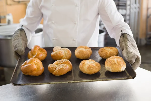 Panadero mostrando bandeja de rollos — Foto de Stock