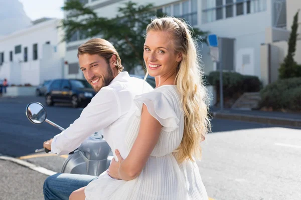 Attractive couple riding a scooter — Stock Photo, Image