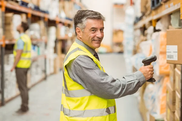 Trabajador de almacén escaneando código de barras en caja — Foto de Stock