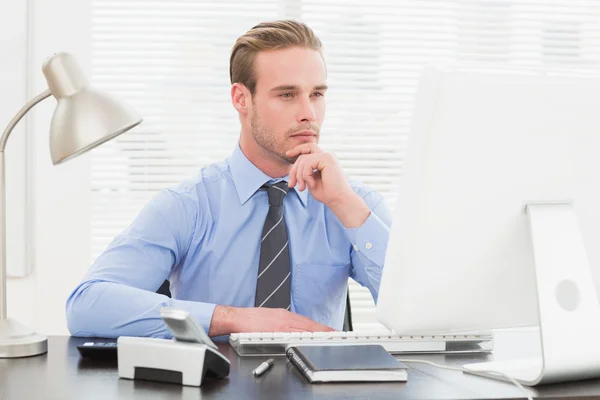 Businessman thinking with hand on chin — Stock Photo, Image