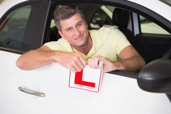 Fröhlicher männlicher Fahrer zerreißt sein L-Schild — Stockfoto