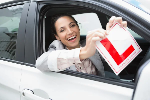 Smiling female driver tearing up her L sign — Stock Photo, Image