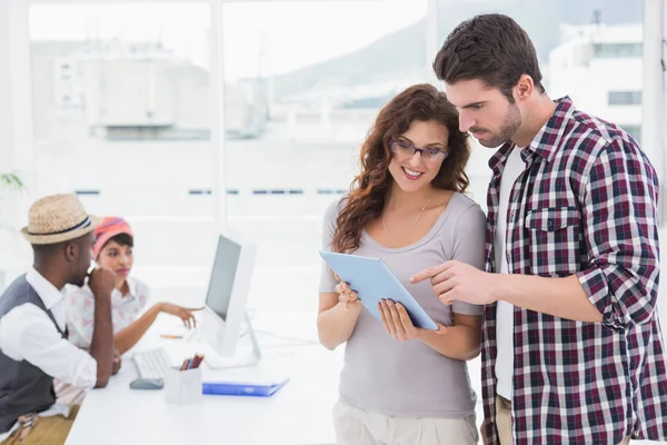 Coworkers standing and using tablet — Stock Photo, Image