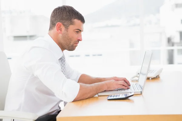 Сфокусированный бизнесмен, работающий над своим ноутбуком — стоковое фото