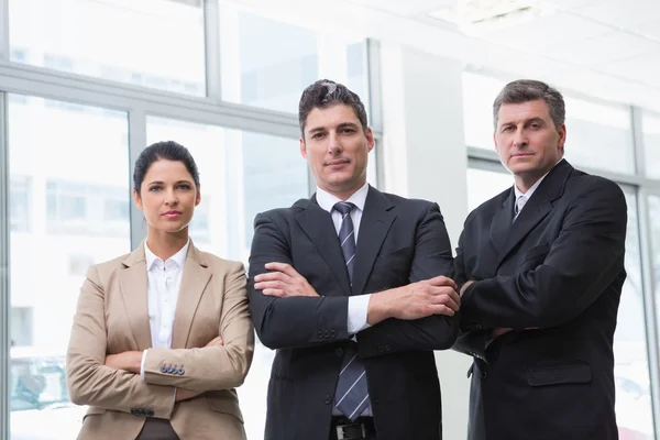 Equipe de negócios séria de pé com os braços cruzados — Fotografia de Stock