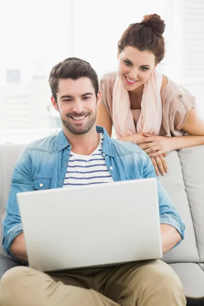 Smiling coworkers using laptop together — Stock Photo, Image