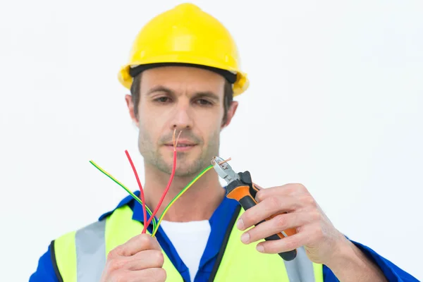Handsome electrician cutting wire with pliers — Stock Photo, Image