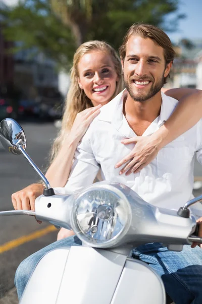 Attractive couple riding a scooter — Stock Photo, Image