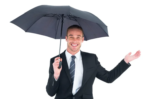 Geschäftsmann versteckt sich unter schwarzem Regenschirm — Stockfoto