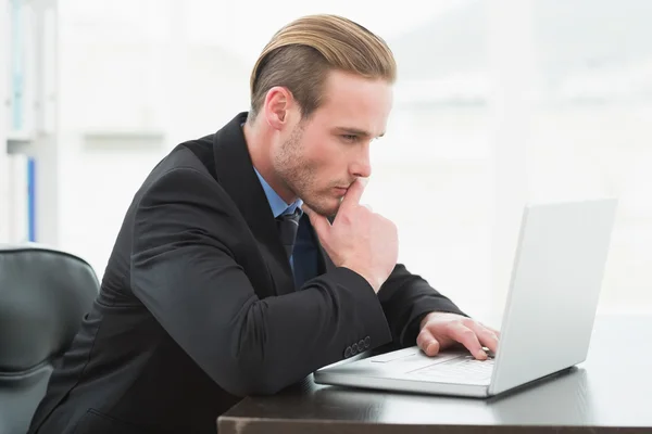 Uomo d'affari concentrato in giacca e cravatta con computer portatile — Foto Stock