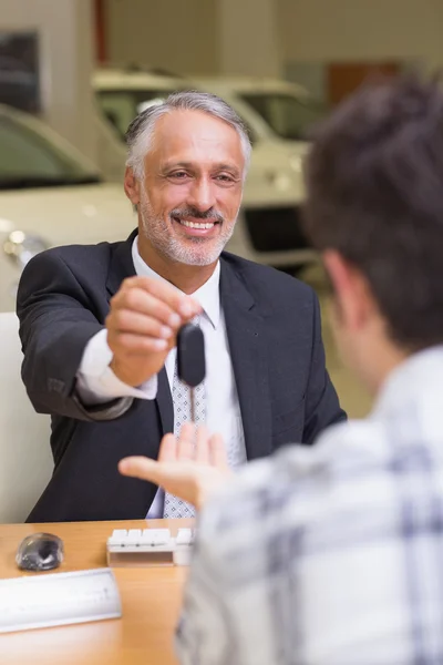 Vendedor dando chaves de um carro de cliente — Fotografia de Stock