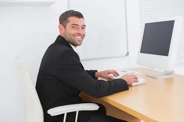 Leende affärsman arbetar vid ett skrivbord — Stockfoto