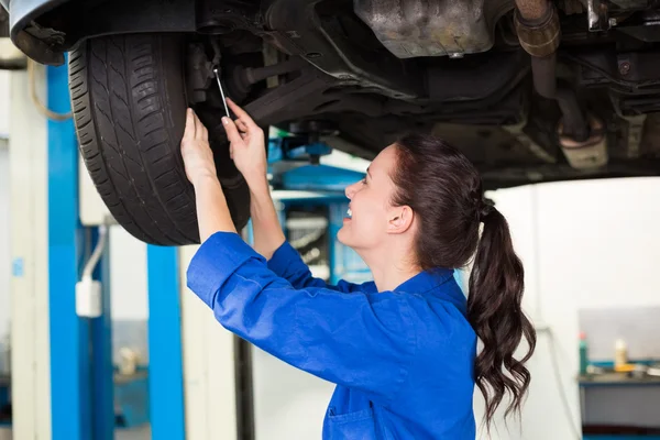 Smiling mechanic adjusting the tire — Stock Photo, Image