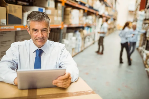 Manager working on tablet pc while looking at camera — Stock Photo, Image