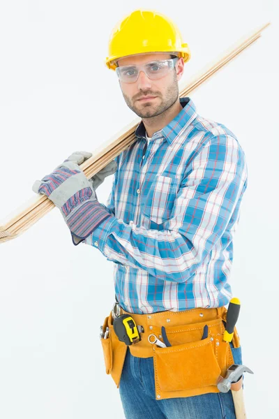 Construction worker carrying wooden planks — Stock Photo, Image