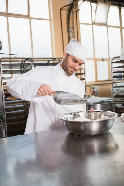 Baker hälla mjöl i bunken — Stockfoto