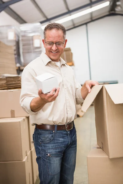 Trabajador de almacén sosteniendo caja pequeña — Foto de Stock