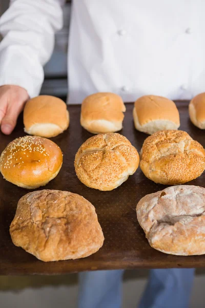 Baker gösteren tepsi ekmek ile — Stok fotoğraf