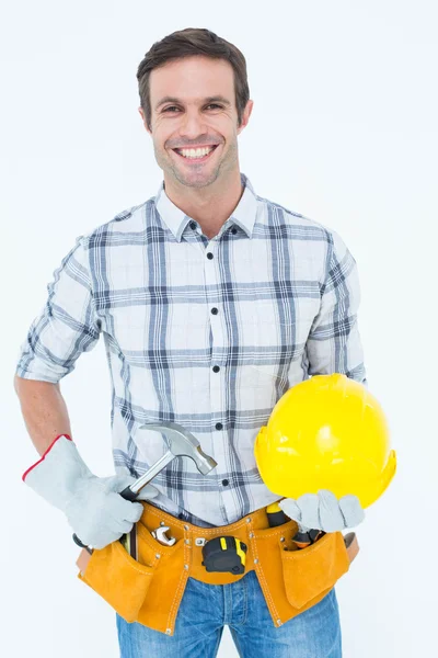 Handyman holding hammer and hard hat — Stock Photo, Image