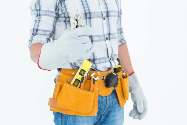 Technician with tool belt holding pliers — Stock Photo, Image