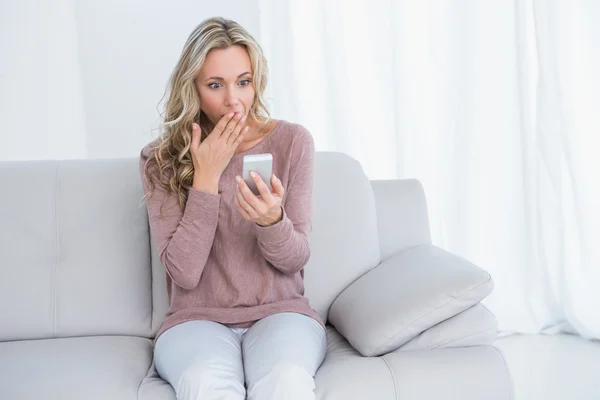 Überraschte Blondine liest Nachricht — Stockfoto