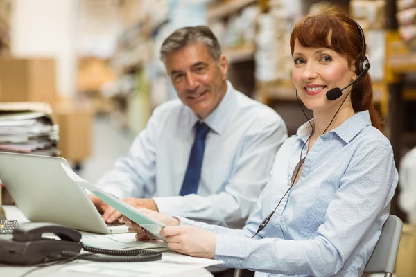 Lagerleiterin am Schreibtisch mit Headset — Stockfoto